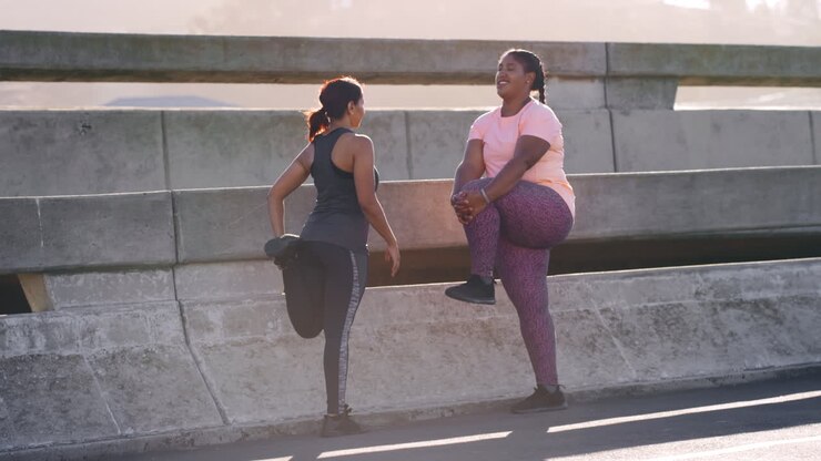 Fitness, friends and women stretching in city