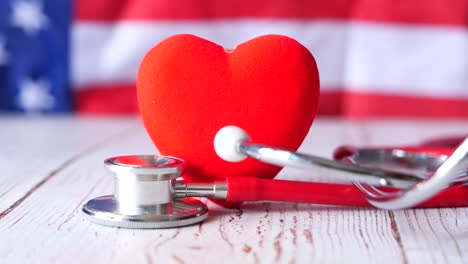 american flag with red heart and stethoscope: healthcare in the usa