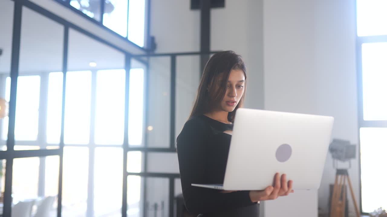 mujer trabajando en una computadora portátil en una oficina moderna