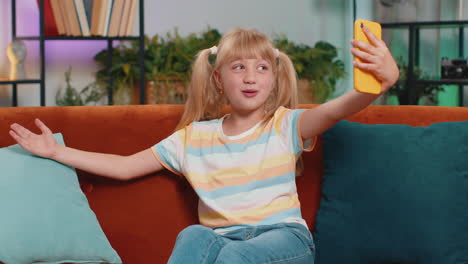 child kid girl taking selfie on smartphone communicating video call home online with subscribers