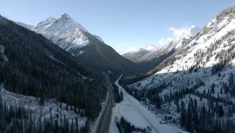 a winter wonderland of majestic rocky mountains and snowy forests, captured from above close to n revelstoke, british columbia