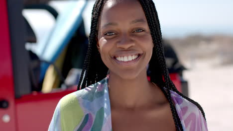 a young african american woman smiles brightly outdoors on a road trip