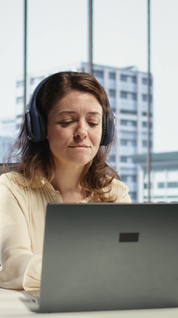 Video verticale. Imprenditrice si diverte a fare multitasking con la sua musica preferita in cuffia.