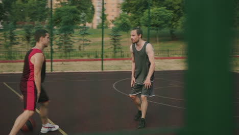 Two-Active-Sportsmen-Playing-In-An-Outdoor-Basketball-Court