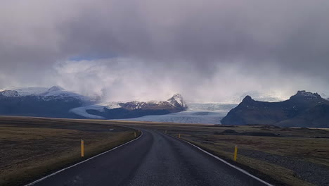 driving on iceland, driver's pov of wet road and glacier, icelandic landscape on spring season