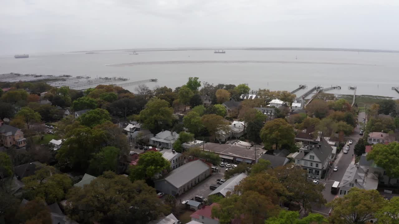 Aerial low panning shot of historic Old Village Mount Pleasant on a hazy day in South Carolina
