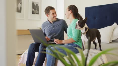 A-young-caucasian-couple-talking-and-paying-their-bills-using-a-laptop