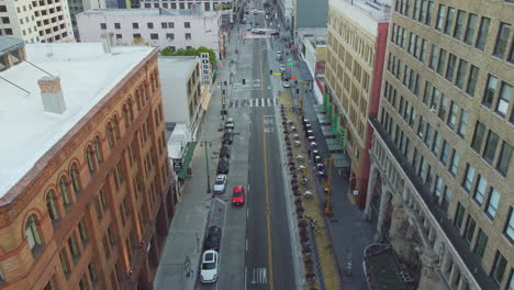 Looking-Straight-Down-Broadway-Main-High-Street,-Los-Angeles,-California,-Drone-Shot-Reveal
