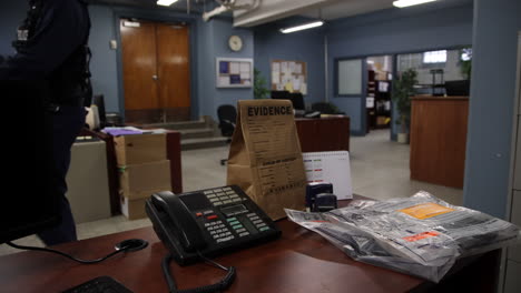 Police-officer-walking-through-precinct-with-evidence-in-foreground