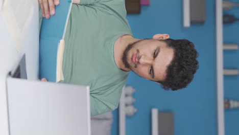 Vertical-video-of-Male-student-bored-with-studying.