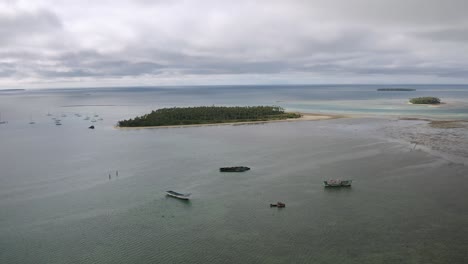 aerial left to right parallax around old fishing boat shipwrecks stranded in shallow water off tongatapu