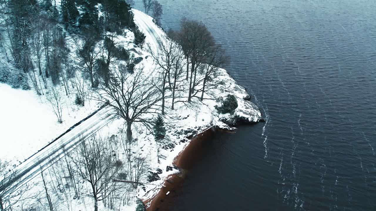 Winter aerial view of snowy lakeshore evoking calm and solitude