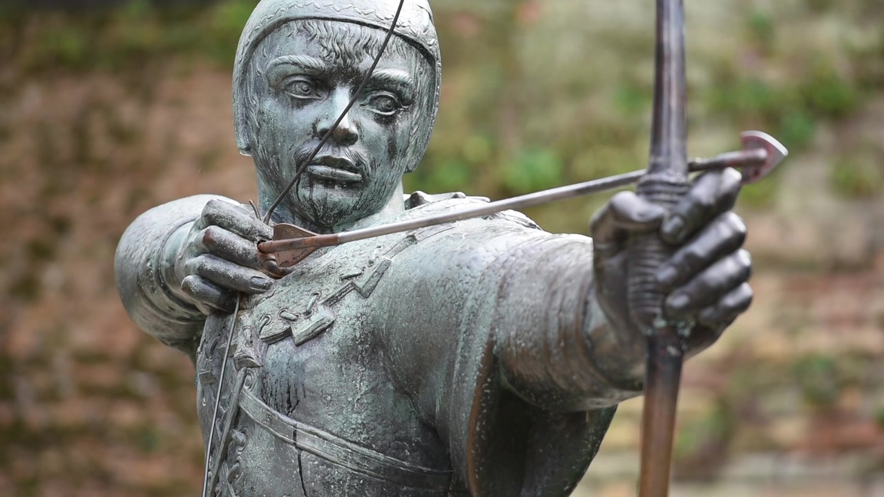 La statua di Robin Hood si erge fiera su Castle Road a Nottingham, Inghilterra, puntando la sua freccia verso lo storico corpo di guardia del Castello di Nottingham