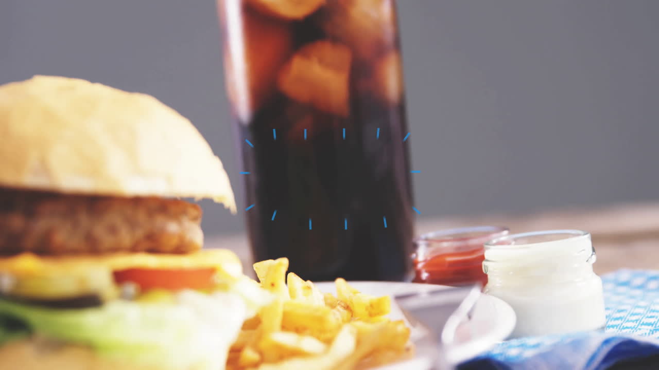 Hambúrguer, batatas fritas e refrigerante na mesa com sobreposição de animação azul