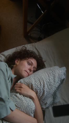 woman sleeping unhappily in bed