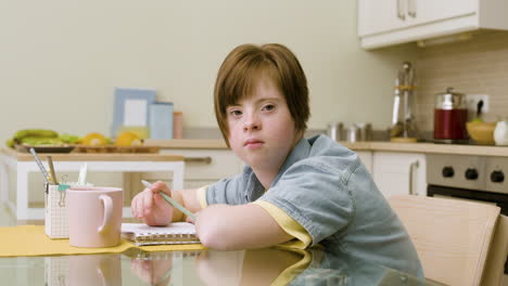 female student doing homework and looking at the camera