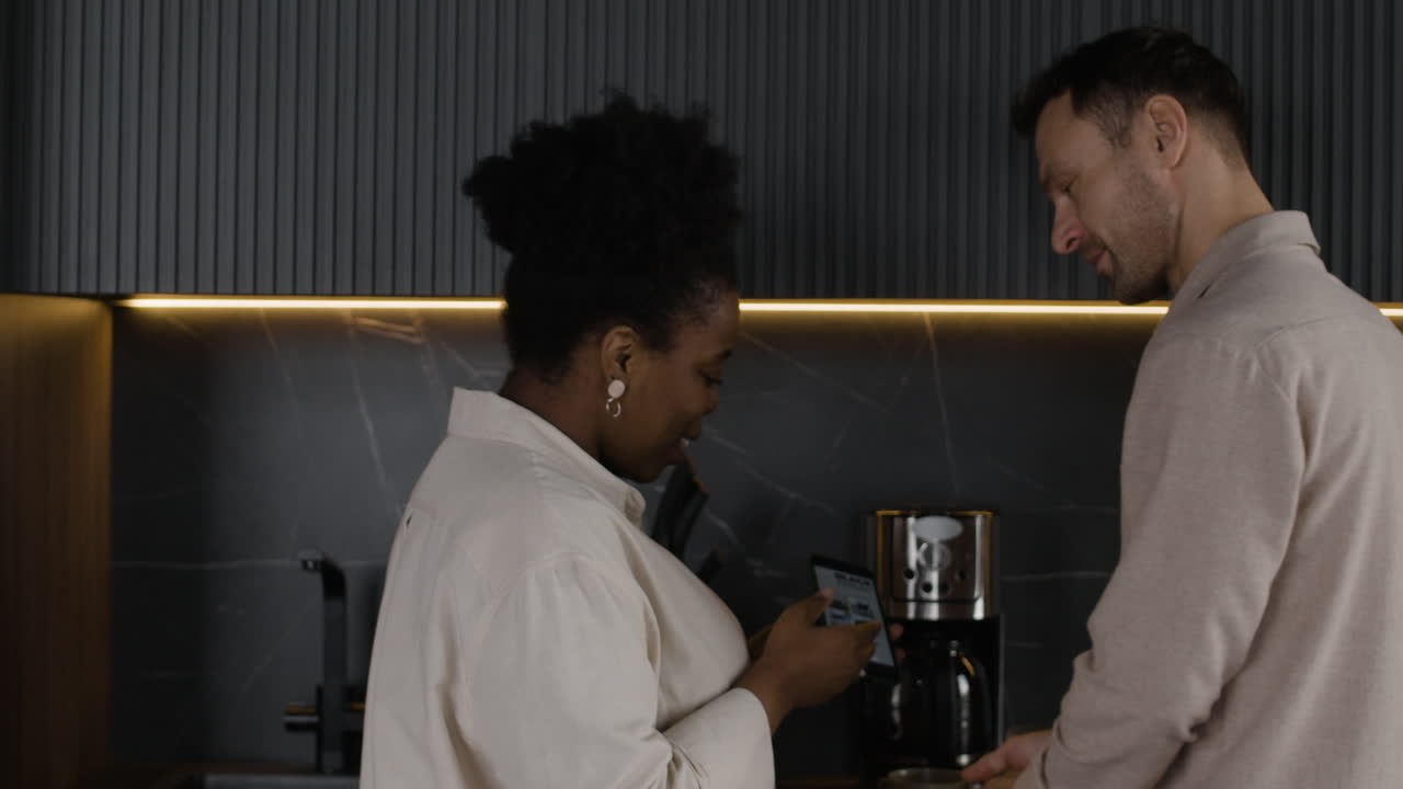 Couple in a modern kitchen using technology and appliances