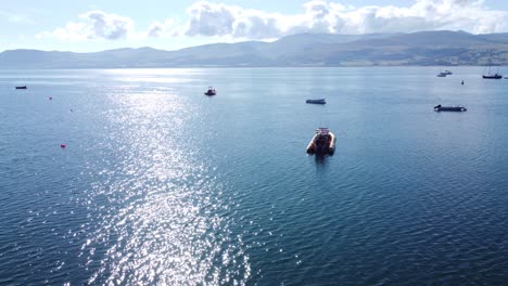 Snowdonia-clear-mountain-range-aerial-view-sunny-calm-Welsh-shimmering-seascape-reversing-right