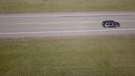 aerial tracking shot as vehicle drives past