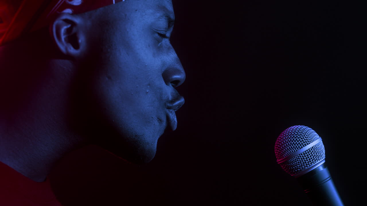 Man Singing into Microphone with Colorful Lighting