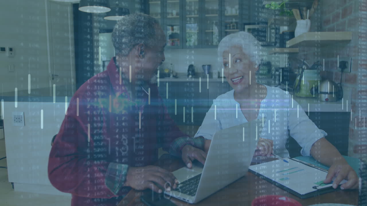 Senior woman and mature man using laptop in kitchen, featuring floating financial charts and data