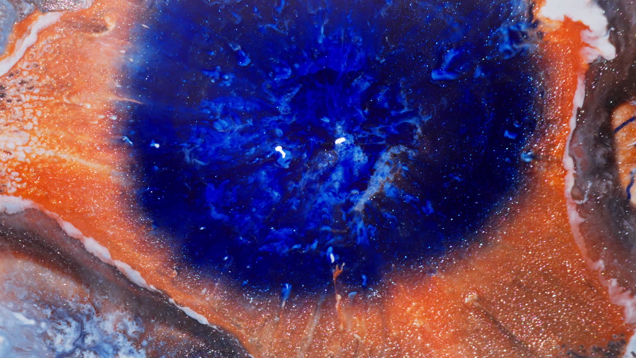 Blue Ink Drops On The Surface With Glittery Orange Surface. - abstract