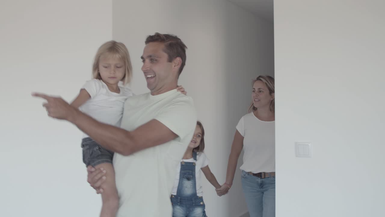 padres felices y dos niños entrando en un nuevo apartamento