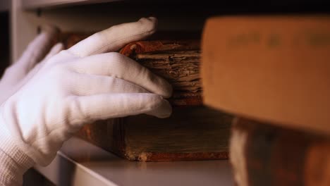 carefully handling historical books in a library