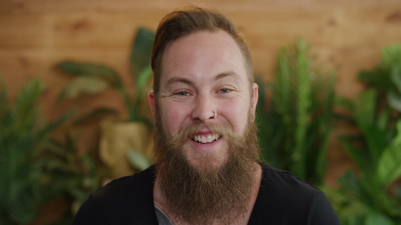 giovane ritratto di un hipster che ride felice godendo dello stile di vita di successo maschio caucasico con la barba che sembra allegro serie di persone reali