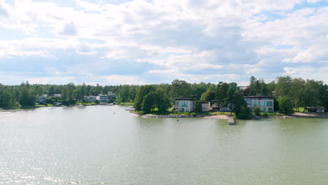 drone flying sideways, low, in front of seaside villas in westend, espoo, finland