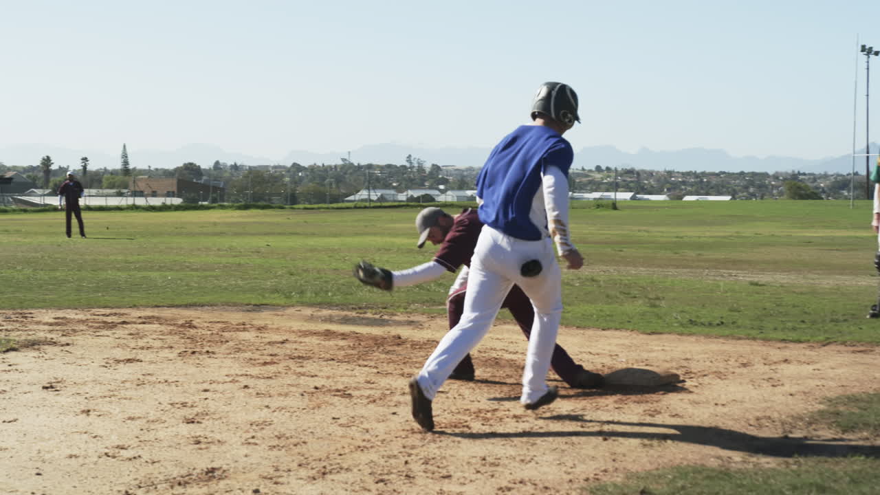 Male baseball players and umpire playing baseball, catching ball and running on a pitch, slow motion