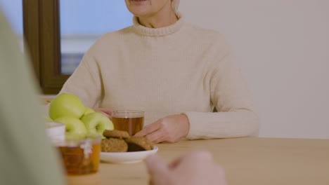 happy senior woman playing guess who game with sticky papers attaching on forehead