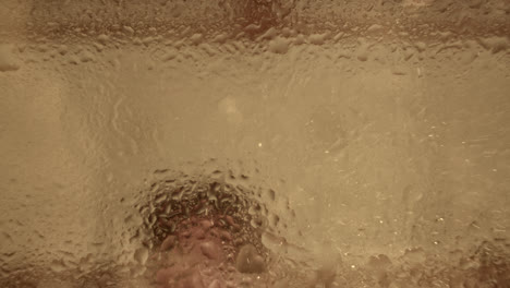abstract view through steamy shower glass with blurred silhouette