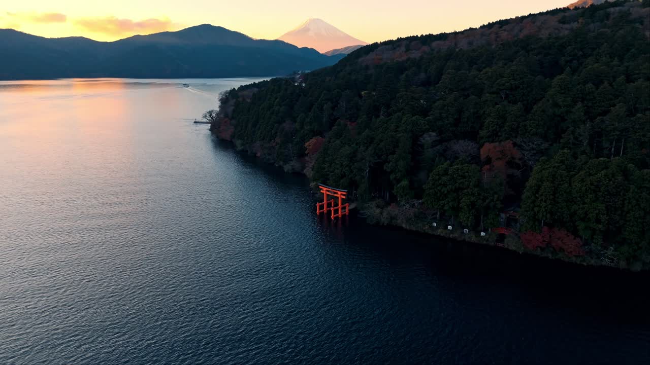 아름다운 해가 지는 동안 아시 호수에 있는 하코네의 유명한 토리 게이트 사원 (torii gate shrine) 을 한눈에 볼 수 있습니다.