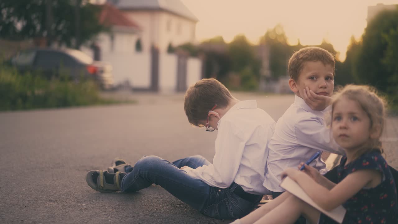 학교 소년은 시험을 준비하고 아스팔트에 친구를 피곤