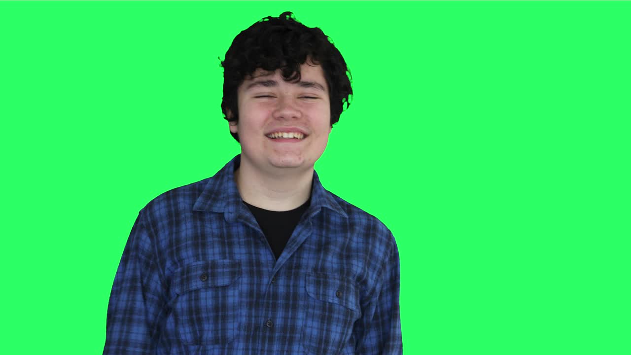 초록색 스크린 배경으로 웃는 십대 소년