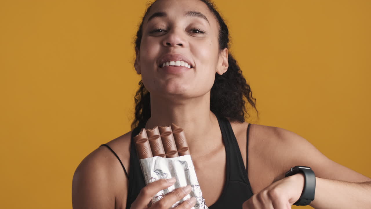 una mujer afroamericana feliz sobre un fondo amarillo.