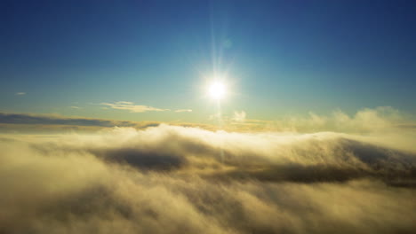 Wolken-Ziehen-über-Berggipfel,-In-Der-Ferne-Scheint-Die-Sonne-Hell---Zeitraffer