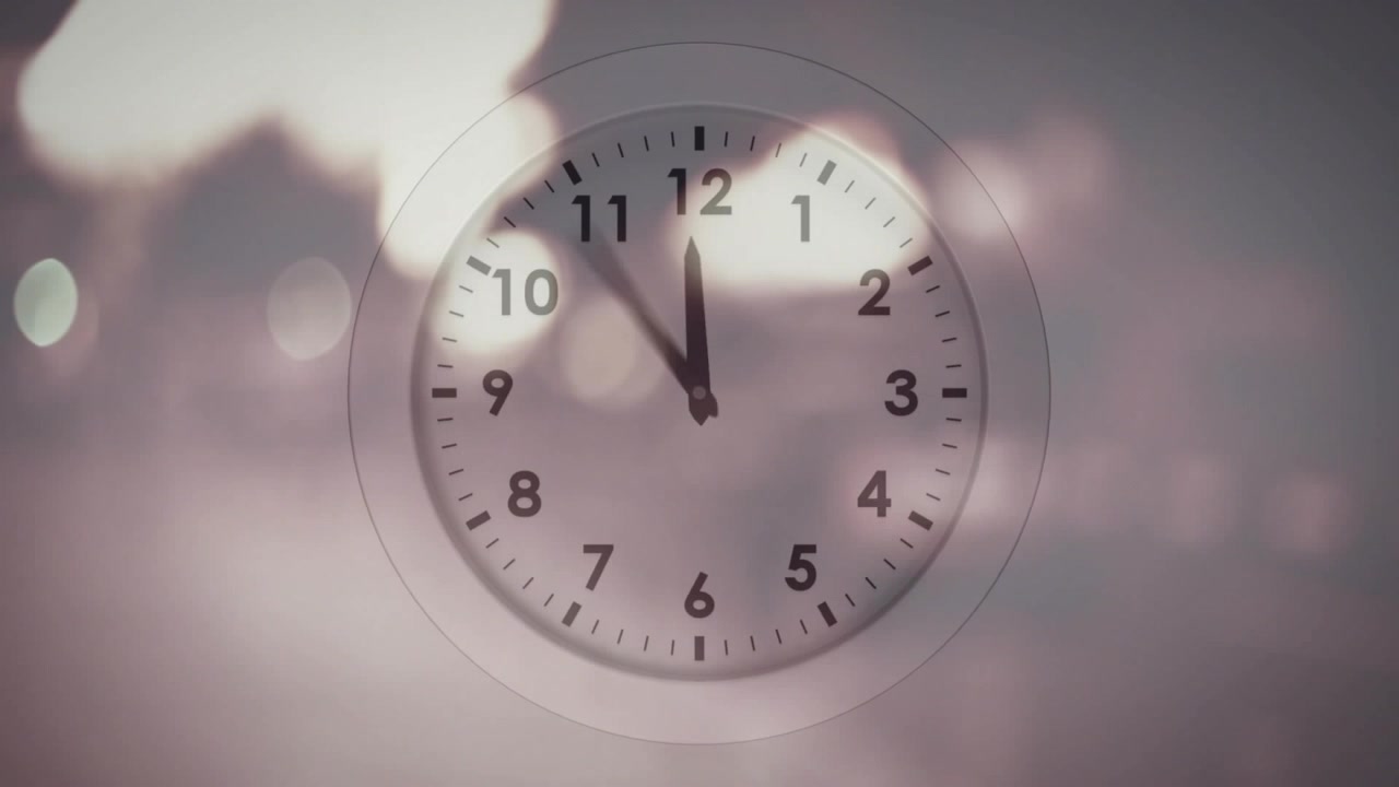 On playback start, clock hands rotating clockwise in steps, blurring, showing time passing