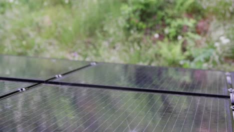 Solar-panels-pelted-by-heavy-rain-on-windy-and-stormy-day,-close-up