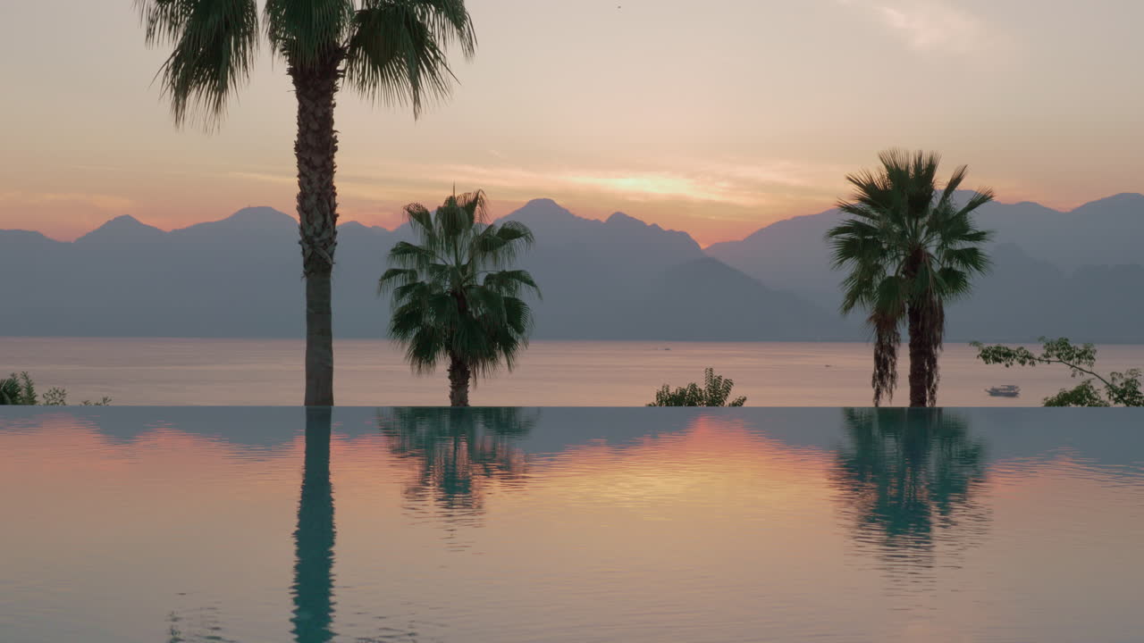 стедикамный снимок блестящей границы бассейна и вечернего морского пейзажа на заднем плане