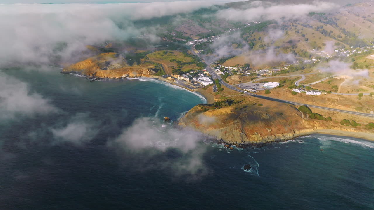 Beautiful rocky coast of sunny Montara State Beach from water. Fog moving on the land from the ocean. Top view.