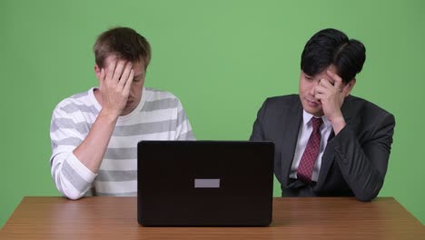 young asian businessman and young scandinavian businessman working together with laptop