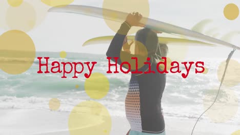 animation of happy holidays text and light spots over senior biracial couple at beach