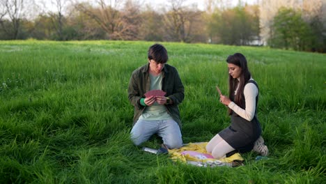 young couple playing cards outdoors
