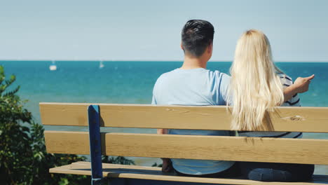 Young-Multi-Ethnic-Couple-Resting-On-A-Bench-Overlooking-Lake-Ontario