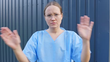 young woman in blue outfit waving hands showing emotion gesture of disallowed or avoidance