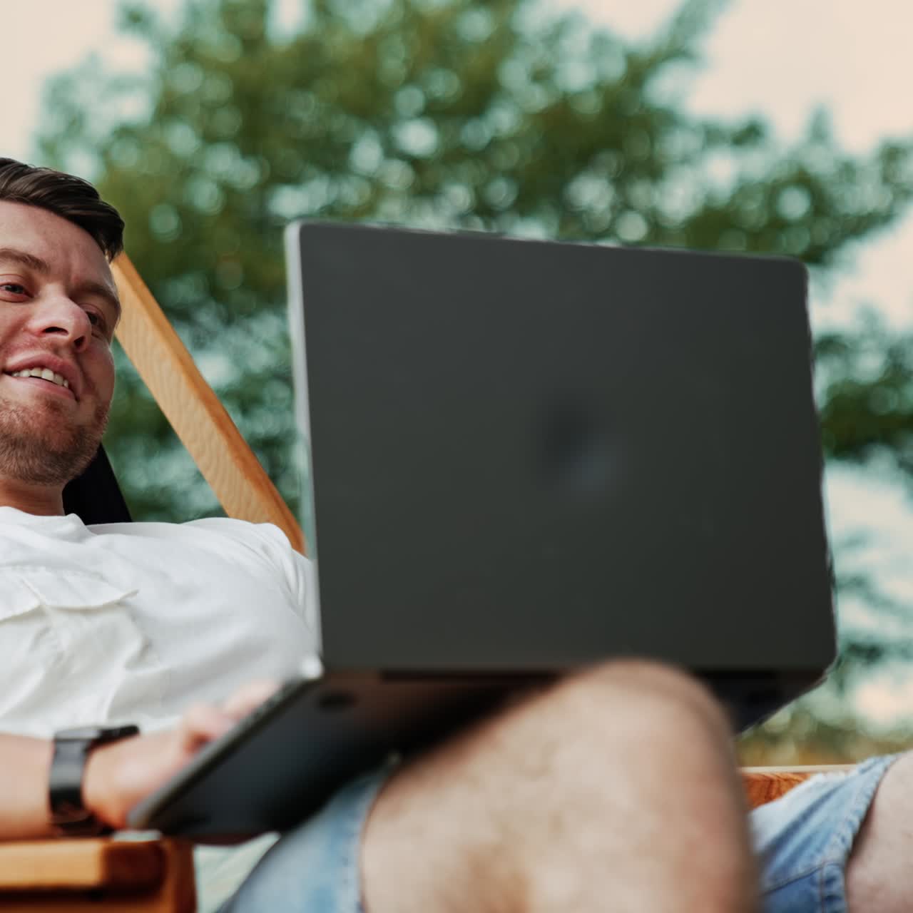Freelancer working on laptop meets a problem. Work in the nature far away from the office. Blurred backdrop