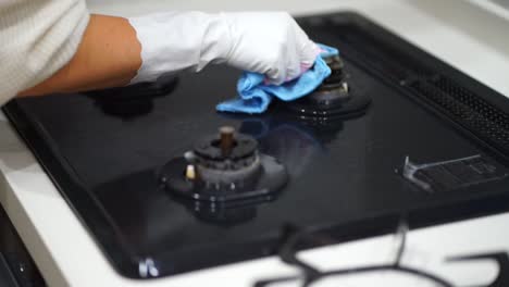 a woman cleaning a gas stove