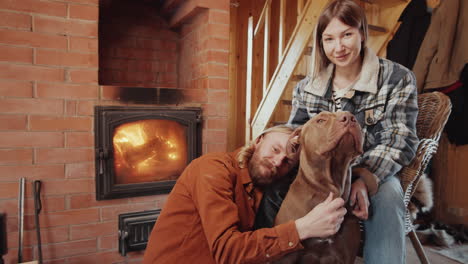 retrato de una pareja feliz con un perro junto a la chimenea en una granja